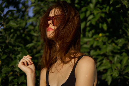 fashionable woman in sunglasses and green leaves summer exotic