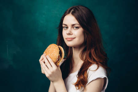 cheerful woman eating hamburger snack close-up lifestyleの写真素材