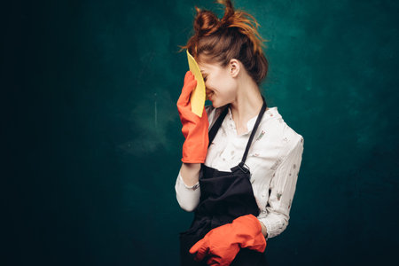 housewife in a black apron with a rag in her hands cleaning