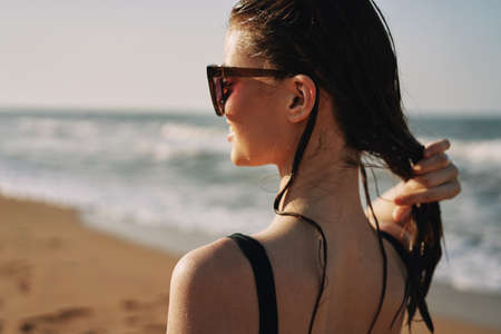 Cheerful woman black swimsuit ocean nature summer tanの写真素材