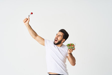 man in white t-shirt plate salad health vegetablesの写真素材