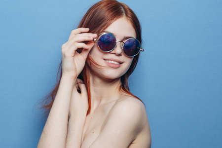 attractive woman with bare shoulders fashionable glasses blue backgroundの写真素材