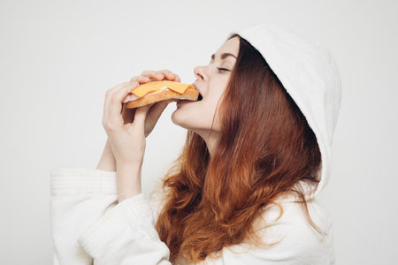 cheerful woman eating sandwich snack fast foodの写真素材