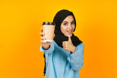 woman in black hijab a glass of coffee in hands near the face studio lifestyleの写真素材