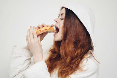 cheerful woman eating sandwich snack fast foodの写真素材
