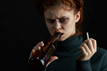 woman with cigarette bottle of alcohol bruises under eyes problems depressionの写真素材