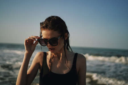 woman in black swimsuit walking on the beach ocean summerの写真素材