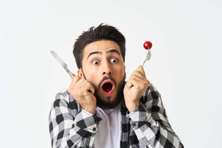 bearded man with kitchen utensils cherry tomatoes snackの写真素材