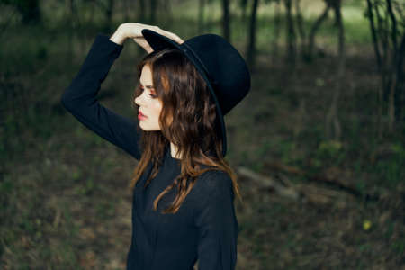 woman in the forest in a black hat gothic style Witch costumeの写真素材