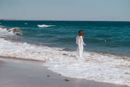 Woman in white dress near the ocean walk fresh air landscapeの写真素材