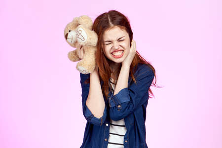 cute woman with little bear toy gift fashion pink backgroundの写真素材