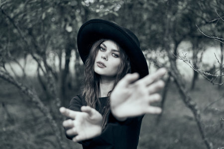 woman in black witch costume in forest nature posing