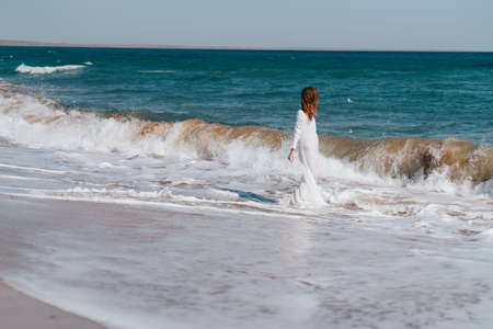 Woman in white dress near the ocean walk fresh air landscapeの写真素材