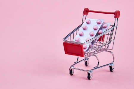 small cart with a pack of drugs pharmacy shopping service medicineの写真素材