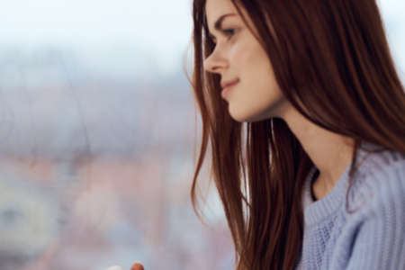 pretty woman dreamy look near window at home restの写真素材