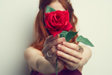 beautiful woman with red hair red rose flower close upの写真素材