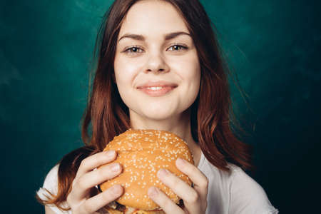 woman eating hamburger fast food snack close-upの写真素材