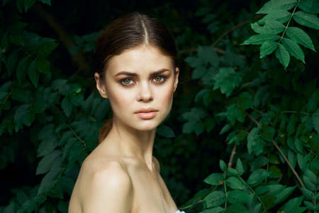 attractive woman skin care bare shoulders green leaves nature close-upの写真素材