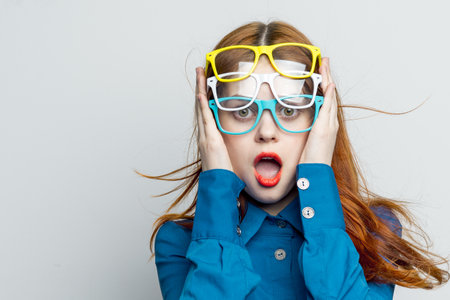 woman with multicolored glasses on her face in blue shirt posing glamorの写真素材