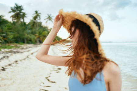 cheerful woman in a beach hat by the ocean island summerの写真素材
