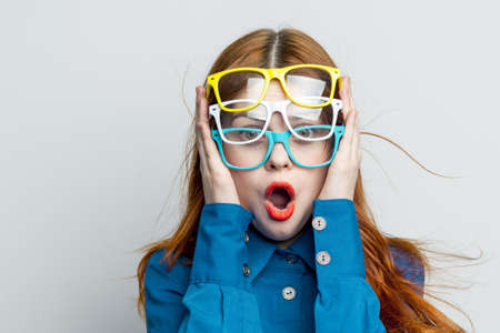 woman with multicolored glasses on her face in blue shirt posing glamorの写真素材