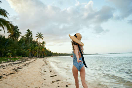 cheerful woman in a beach hat by the ocean island summerの写真素材
