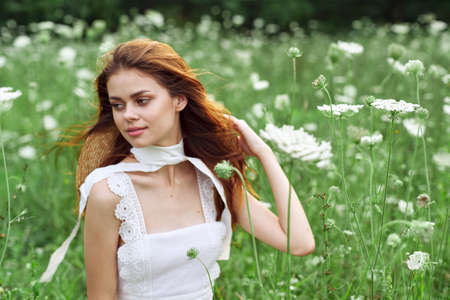pretty woman in white dress and hat posing flowers natureの写真素材