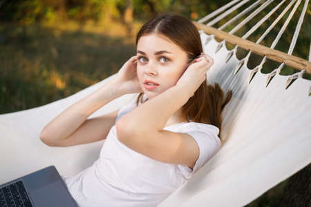 woman with laptop and lies in a hammock vacation nature freelanceの写真素材