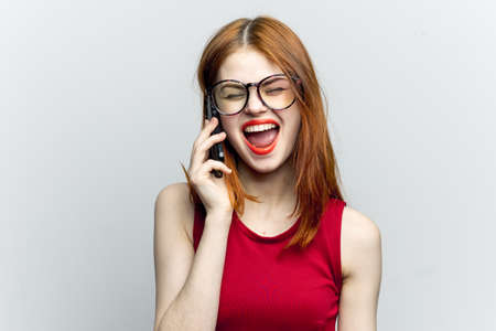 emotional red-haired woman with a phone in her hands communicating gadgetの写真素材