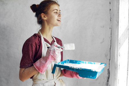 woman with brush in hands paint inside home interior renovationの写真素材