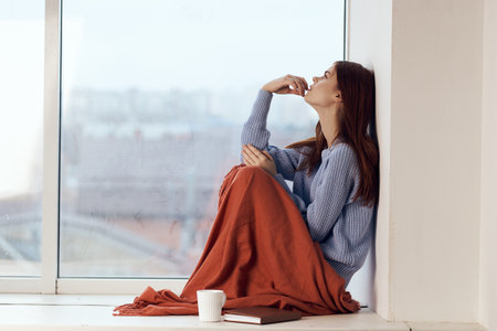 woman sitting on windowsill rest plaid morning lifestyleの写真素材