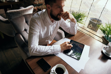 business man in a cafe with a tablet in his hands technology workの写真素材