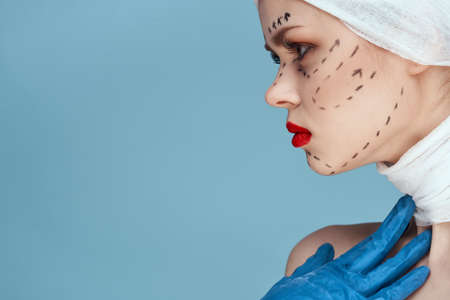 woman posing in blue gloves red lips surgery facial rejuvenation studio lifestyleの写真素材