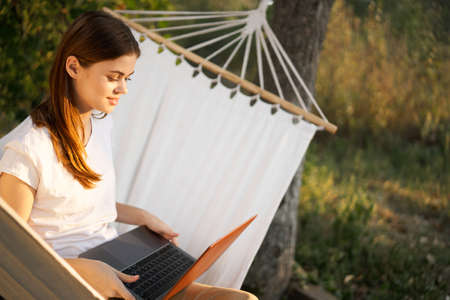 woman working on laptop in nature hammock freelanceの写真素材