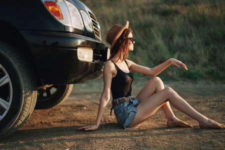 woman in sunglasses near car travel summer vacation landscapeの販売画像