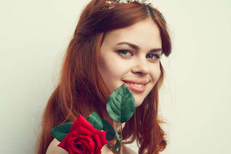 beautiful red-haired woman rose flower close-up charmの写真素材