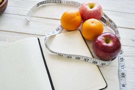 notepad on table measuring tape fruit breakfast nutritional fitnessの写真素材