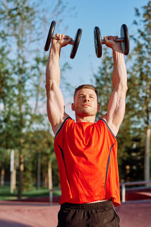 Muscled Man With Dumbbells Workout Outdoor Fitnessの写真素材