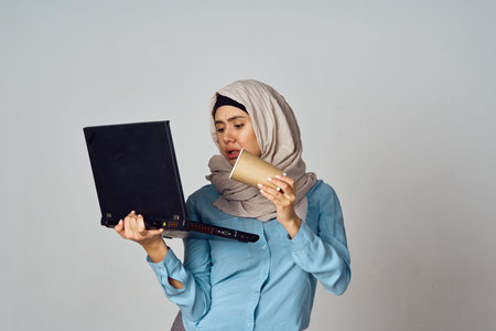 muslim woman in hijab with laptop coffee cup workの写真素材
