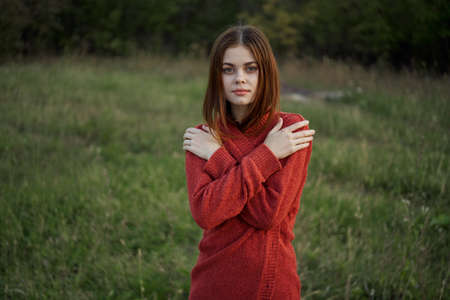 woman in a red sweater outdoors in the field nature restの写真素材