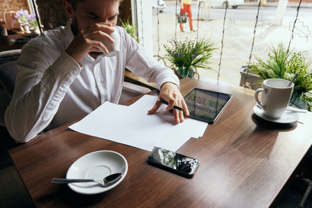business man in a cafe with a tablet in his hands technology workの写真素材