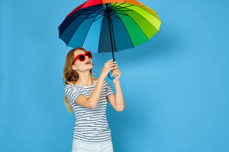 pretty woman fashion posing colorful umbrella blue backgroundの写真素材