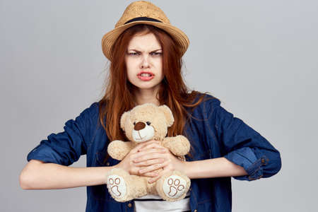 cheerful woman in a hat with a teddy bear gift toyの写真素材
