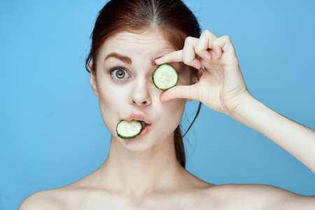 woman with bare shoulders cucumber vitamins health blue backgroundの写真素材