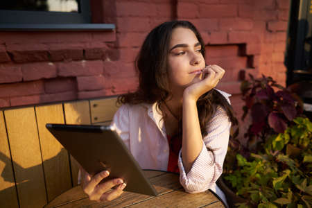 woman in a summer cafe sits by the table morningの写真素材