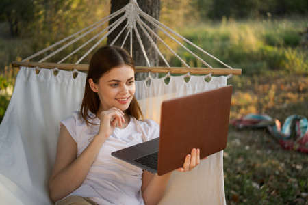 woman with laptop and lies in a hammock vacation nature freelanceの写真素材