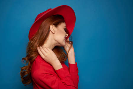 beautiful woman attractive look posing red hat blue backgroundの写真素材