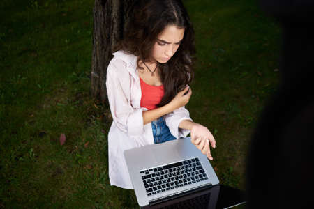 woman outdoors sitting on the grass business technologyの写真素材