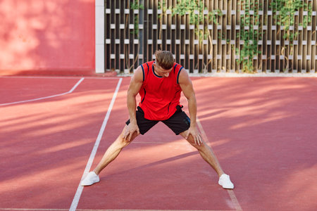 athletic man in red jersey on the sports ground exerciseの写真素材