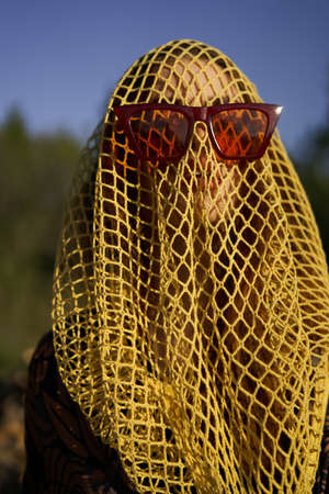 pretty woman wearing sunglasses veil dark backgroundの写真素材